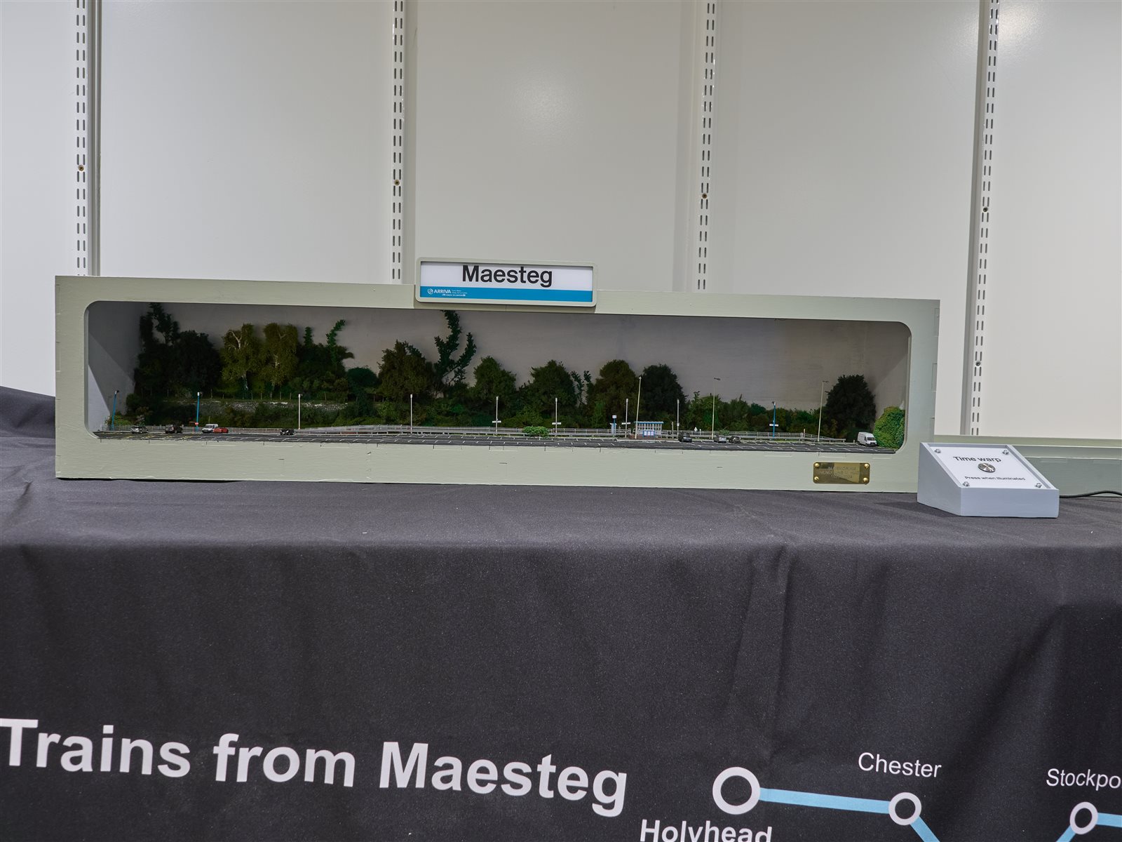 Front view of the complete Maesteg layout in its proscenium case with totem sign and Time Warp box
