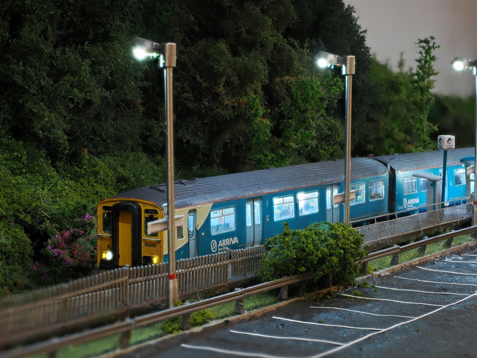 Class 150 150259 under illuminated platform lamps at dusk