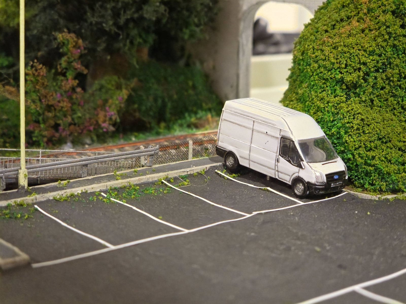 White Transit van parked beside the road overbridge at the eastern end